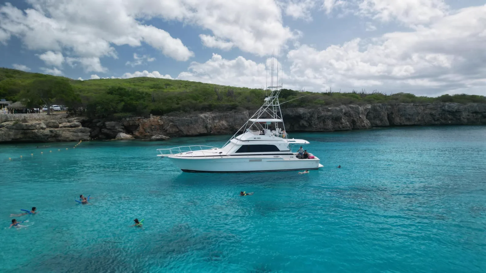 Harmony yacht with guests swimming in turquoise Curaçao water